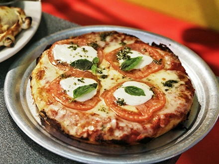$11 por 1 de las NUEVAS Pizzas personales de 4 pedazos, a escoger entre “Margarita” con mozzarella fresca de buffalo, rodajas de tomate natural y albahaca orgánica del patio o “La Chimi” con queso mozzarella, chorizo parrillero y chimichurri de la casa + 1 Empanada al horno, a escoger entre Cebolla y mozzarella, Carne, Pollo, Pepperoni o Capresse + 1 Copa de sangría de la casa